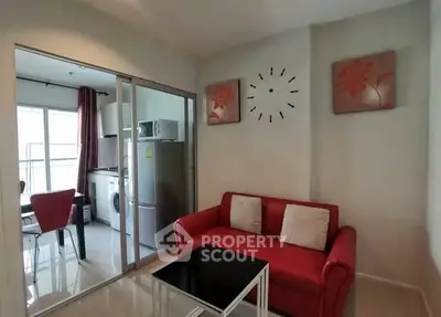 Cozy living room with red sofa and modern kitchen view