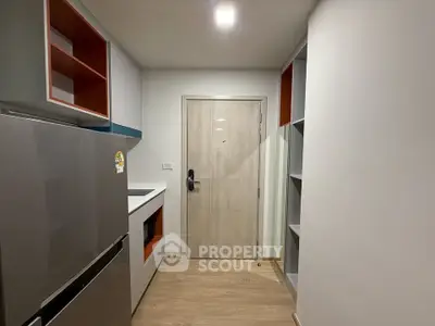 Modern kitchen with sleek appliances and minimalist design in a compact space.