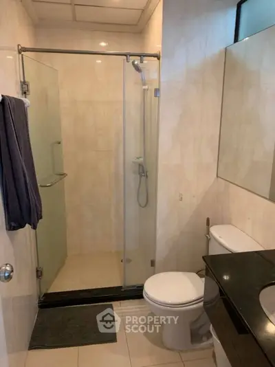 Modern bathroom with glass shower and sleek black countertop