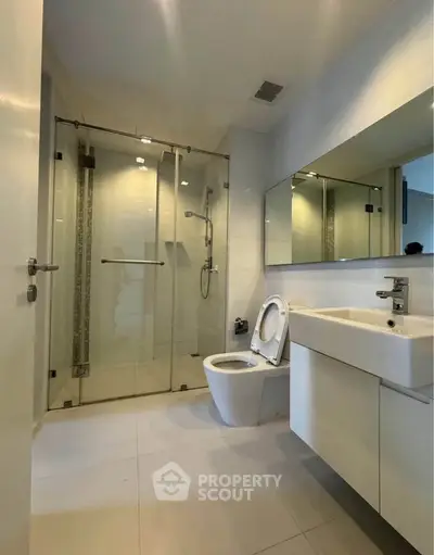 Modern bathroom with glass shower and sleek fixtures in a contemporary home.