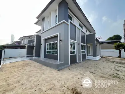 Modern two-story house with sleek design and spacious yard in suburban neighborhood.