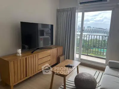 Modern living room with balcony view, featuring sleek furniture and a large TV, perfect for relaxation.