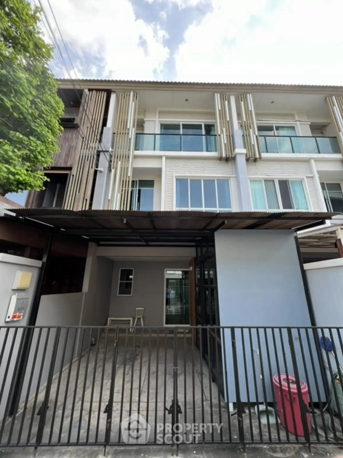 Modern townhouse exterior with gated parking and contemporary design.