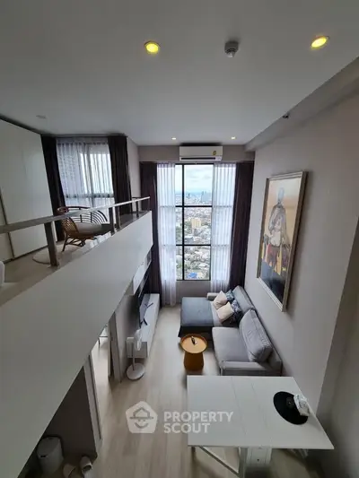 Modern loft apartment with high ceilings and city view, featuring stylish living area and mezzanine.