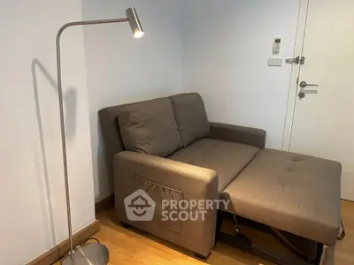 Cozy living room with a modern sofa bed and sleek floor lamp, perfect for small spaces.