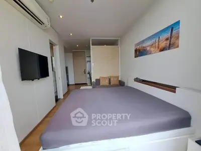 Modern bedroom with minimalist decor and wall art, featuring a comfortable bed and mounted TV.
