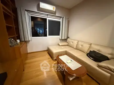 Cozy living room with modern beige sofa and wooden flooring, perfect for relaxation.