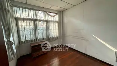 Cozy empty room with wooden floors and large windows, perfect for customization.
