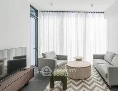 Modern living room with sleek furniture and large windows for natural light.