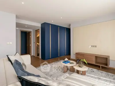 Modern living room with stylish furniture and blue accent wall, perfect for relaxation.