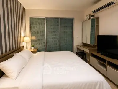 Modern bedroom with stylish decor and ample storage space, featuring a comfortable bed and sleek furniture.