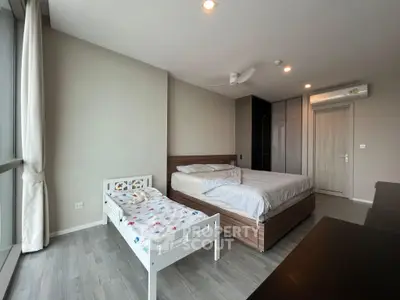 Spacious bedroom with modern decor and large windows for natural light