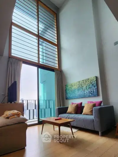 Spacious living room with high ceiling and large windows in modern apartment