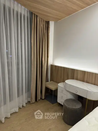 Elegant bedroom corner with modern furniture and floor-to-ceiling curtains