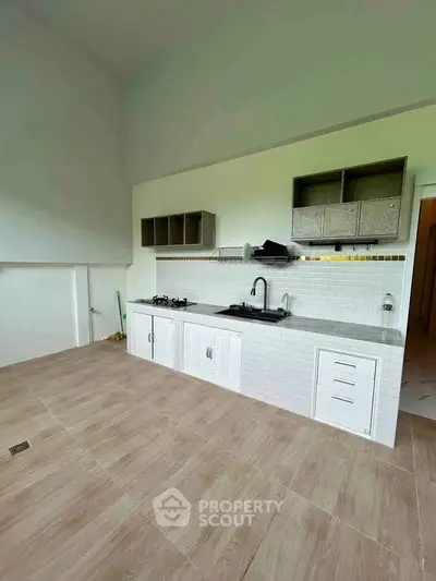 Spacious kitchen with modern open layout and gas stove in a bright apartment.