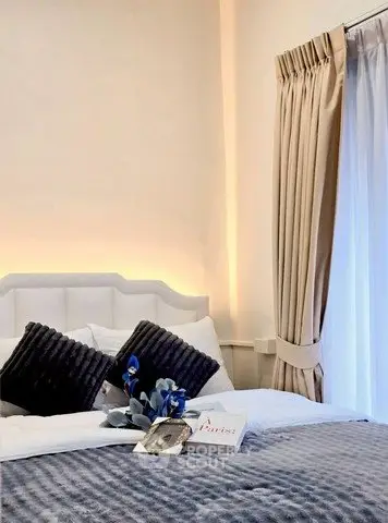 Elegant bedroom with plush bedding and stylish decor, featuring soft lighting and luxurious curtains.