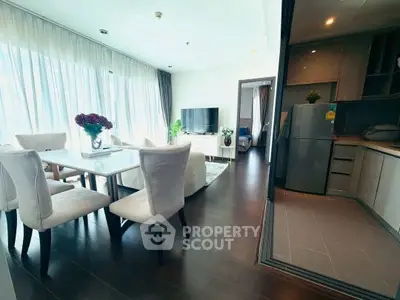 Spacious modern living room with dining area and open kitchen in a bright apartment.