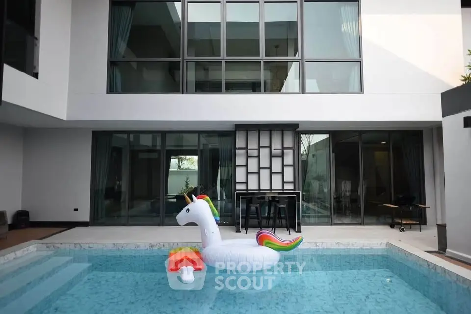 Luxurious modern home with private pool and unicorn float, perfect for relaxation and entertainment.