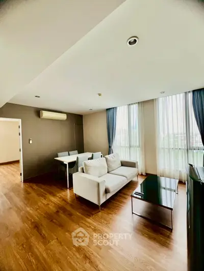 Spacious modern living room with elegant decor and large windows for natural light.