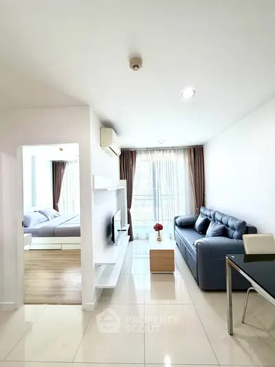 Modern living room with sleek design, featuring a cozy sofa and bright natural light from large windows.