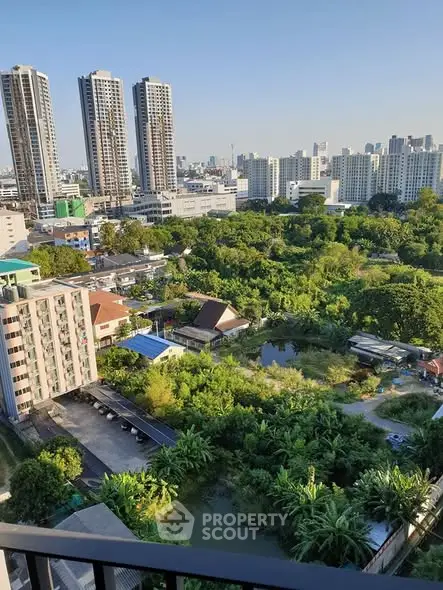 Stunning cityscape view from a high-rise balcony overlooking lush greenery and urban skyline.