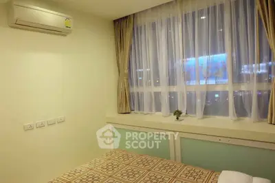 Cozy bedroom with large window and air conditioning in modern apartment