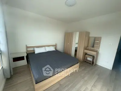 Spacious bedroom with modern wooden furniture and natural light