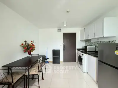 Modern kitchen with dining area, featuring sleek appliances and stylish decor in a bright, open space.
