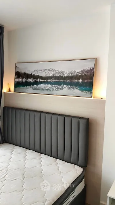 Modern bedroom with stylish headboard and scenic artwork, perfect for relaxation and comfort.