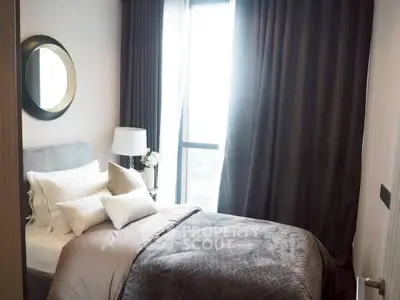 Cozy bedroom with elegant decor and large window for natural light