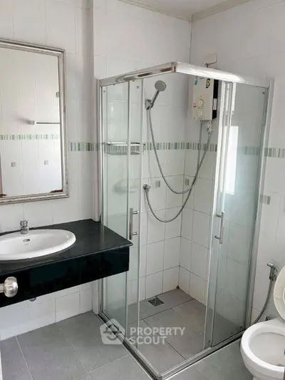 Modern bathroom with glass shower enclosure and sleek vanity.