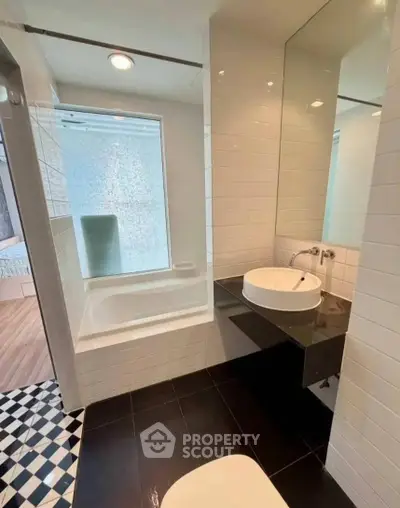 Modern bathroom with sleek design, featuring a bathtub and stylish sink in a contemporary apartment.