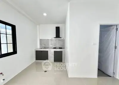 Modern minimalist kitchen with sleek cabinetry and gas stove in bright white interior.