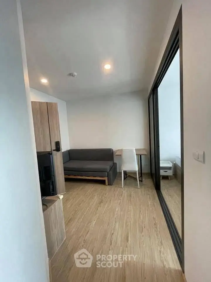 Modern living room with sleek wooden flooring and stylish furniture in a cozy apartment.