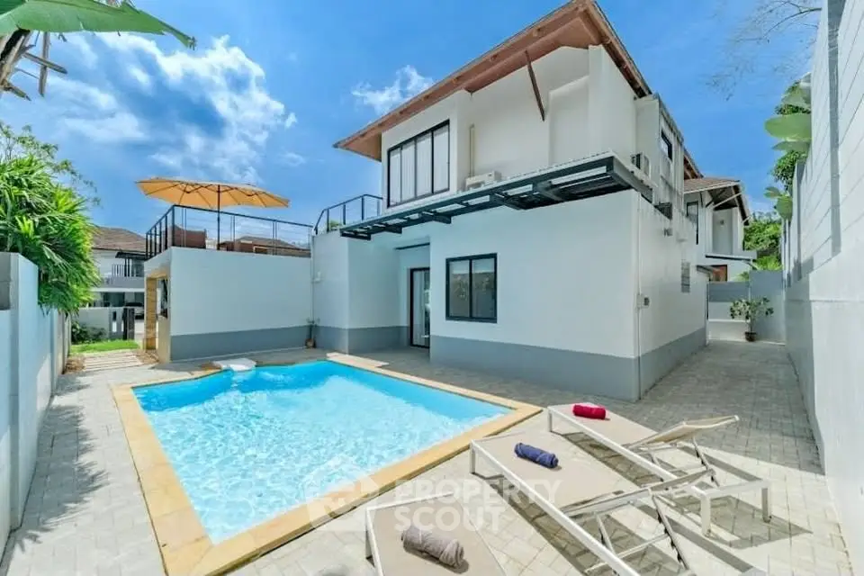 Stunning modern villa with private pool and spacious outdoor area under clear blue skies.