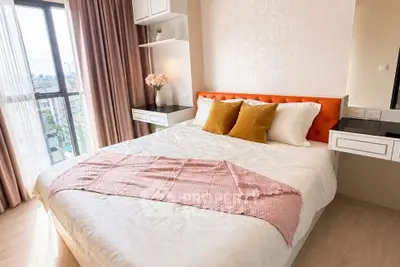 Modern bedroom with city view, featuring stylish decor and cozy ambiance.
