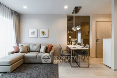 Modern living room with elegant decor and dining area, featuring a cozy sofa and stylish lighting.