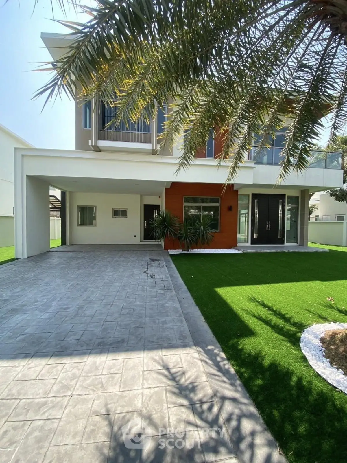 Modern two-story house with lush green lawn and spacious driveway