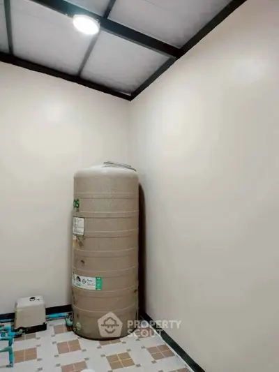 Utility room with large water tank and tiled floor, ideal for storage solutions.