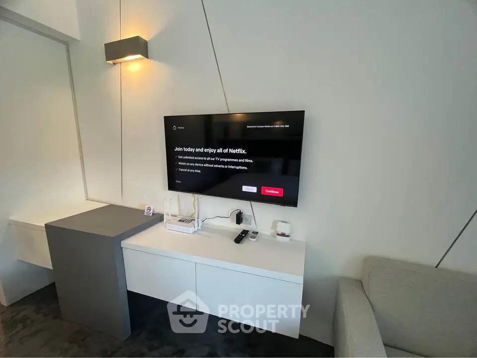 Modern living room with wall-mounted TV and sleek furniture