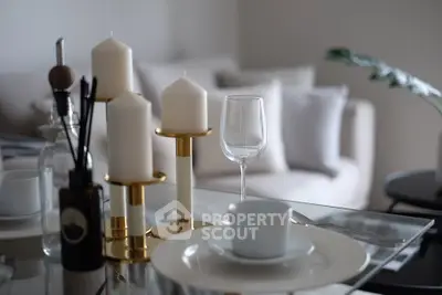 Elegant dining setup with candles and glassware in modern living room