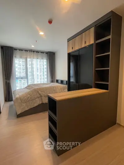 Modern bedroom with stylish furniture and large window offering city view