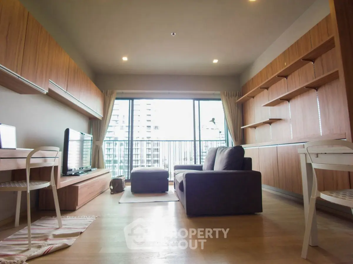 Spacious living room with modern furniture and large windows offering city views.