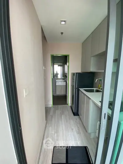 Modern compact kitchen with sleek cabinetry and integrated appliances in a stylish apartment.