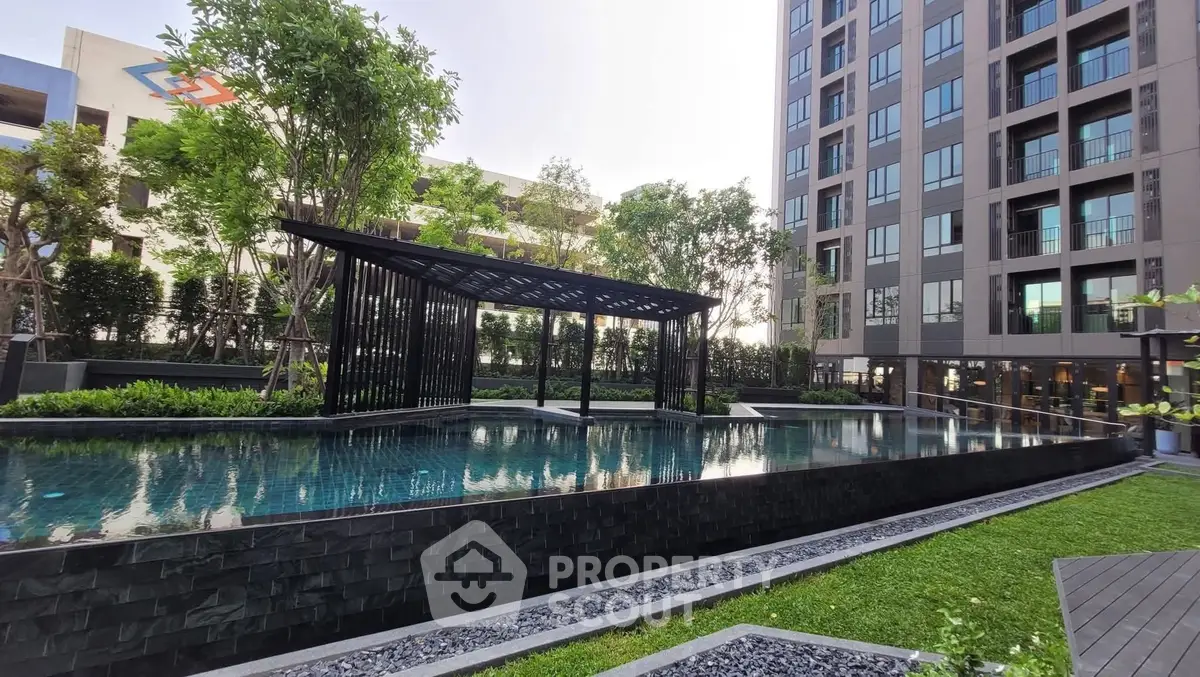 Modern apartment complex with luxurious pool and lush greenery