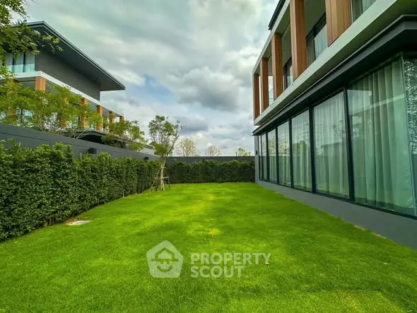 Luxurious modern home with expansive green garden and large windows