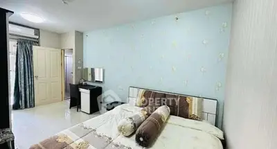 Spacious bedroom with elegant decor and ample natural light in modern apartment.