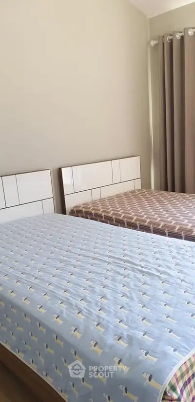 Cozy bedroom with twin beds and modern decor, perfect for comfortable living.
