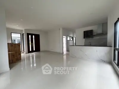 Spacious modern living room with open kitchen layout and sleek marble countertops.
