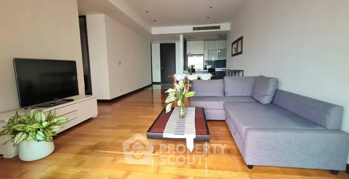 Spacious modern living room with sleek furniture and open kitchen layout.